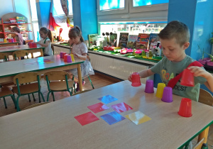 Dzieci oglądają ułożony kod z kolorowych kartek